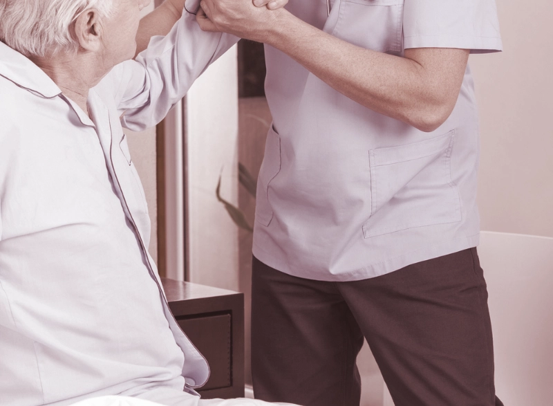 Zorgverlener help client uit bed